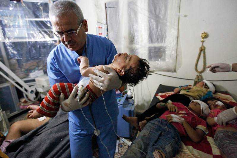 Fotoğraf 2, Robert King: "Bu fotoğraf cephedeki bir doktorun cesaret ve gücünü simgeliyor. Mide bağırsakları uzmanı olan doktor Kasım, Esad rejimi tarafından terörist olarak adlandırılıyor. Onun mücadelesi ise, Esad ordusunun tankları tarafından vurulan 6 çocuğu iyileştirmeye çalışmak." (ntv.com.tr)